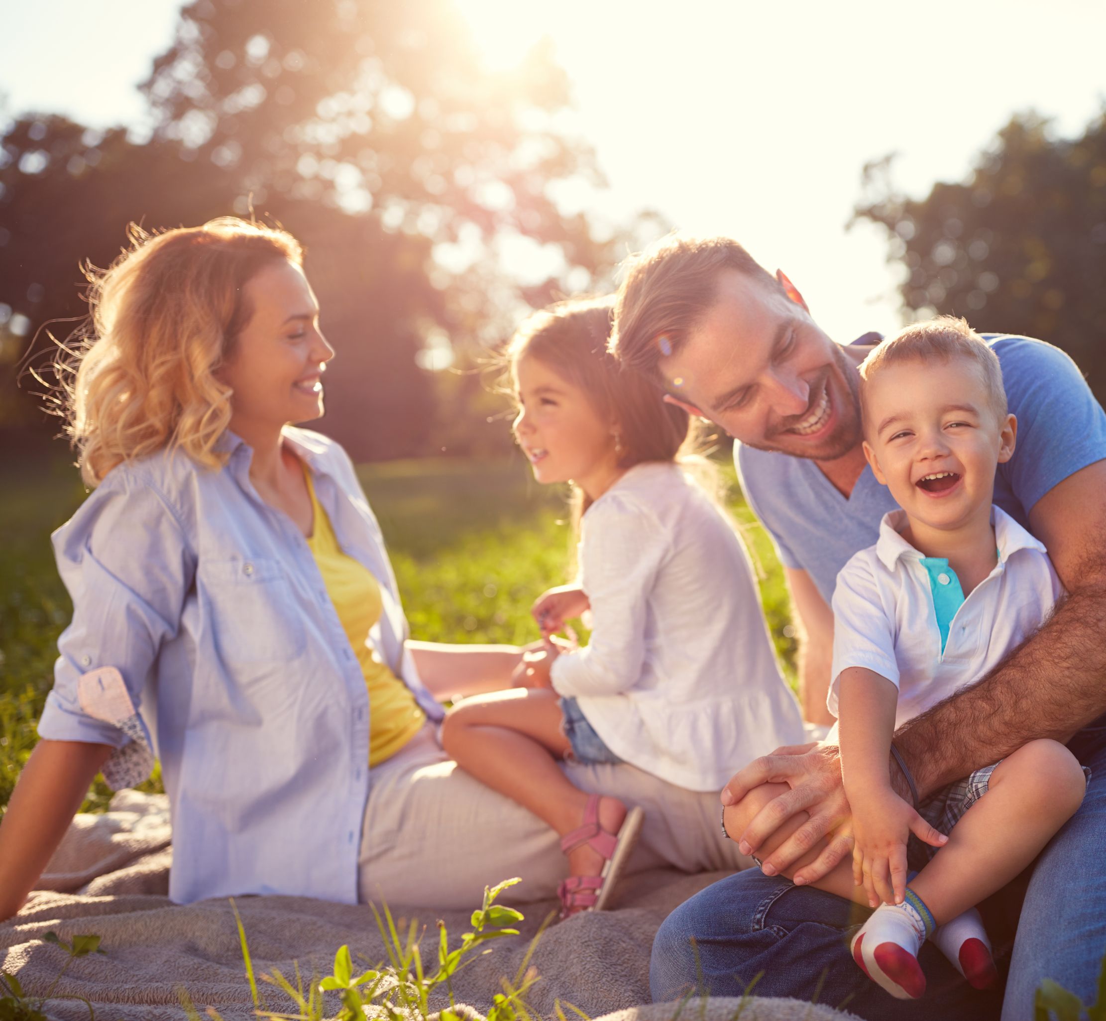 Happy family sat outside on the grass